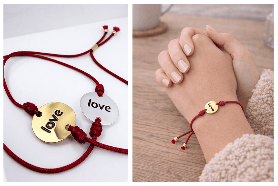 Splecione dłonie na drewnianym stole, na nadgarstku czerwona bransoletka z medalikiem „love”; w drugim ujęciu dwa warianty zawieszki – złoty i srebrny