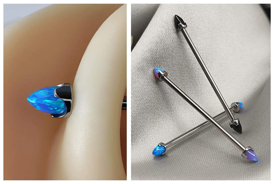 Industrial z niebieskim opalem – sztanga przeprowadzona przez ucho + końcówki w kształcie stożków bullet an tle tkaniny