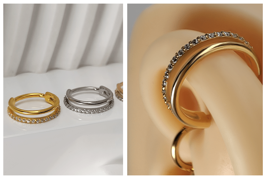 Trzy kółka clicker podwójny ring z kryształami ułożone na jasnym podłożu oraz detal złotego kolczyka w silikonowym uchu