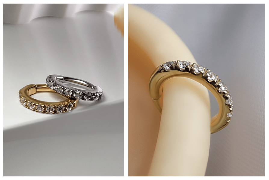 Złoty i srebrny owalny clicker z rantem kryształków na białym podłożu oraz zbliżenie złotego modelu w uchu