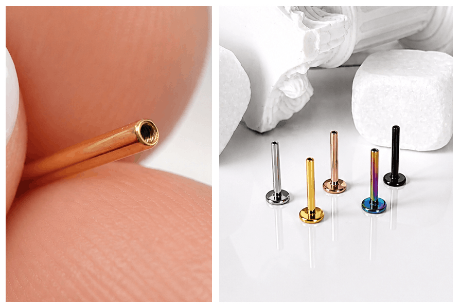 Zbliżenie na tytanowy labret (pręt) z gwintem wewnętrznym oraz zestaw pięciu kolorowych prętów do piercingu ustawionych obok siebie na jasnym tle