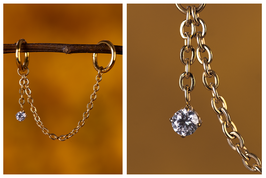 Złoty łańcuszek asymetryczny z wiszącym kryształkiem, doczepiony do kolczyków kółek i pokazany w detalu na ogniwa