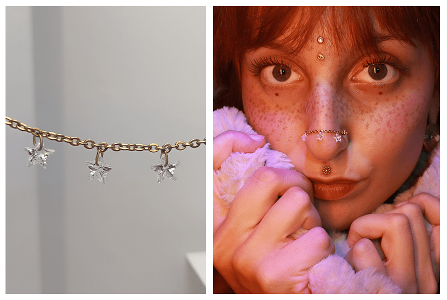 Zbliżenie na złoty łańcuszek z trzema kryształowymi gwiazdkami do kolczyków oraz stylizacja na nosie u modelki z kilkoma innymi przekłuciami