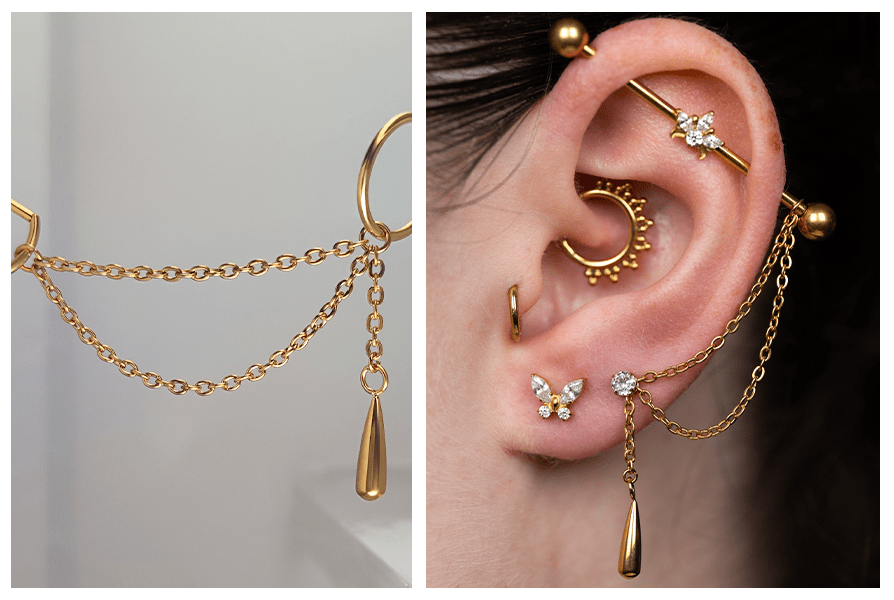 Złoty łańcuszek asymetryczny z zawieszką w kształcie łezki, przypięty do kolczyków przy kilku piercingach ucha