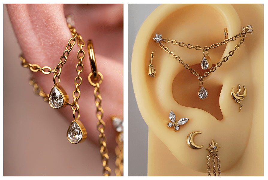 Podwójny łańcuszek do kolczyków z dwiema wiszącymi kryształowymi łezkami, zawieszony między kółkami na gałązce i na modelu ucha z inną złotą biżuterią