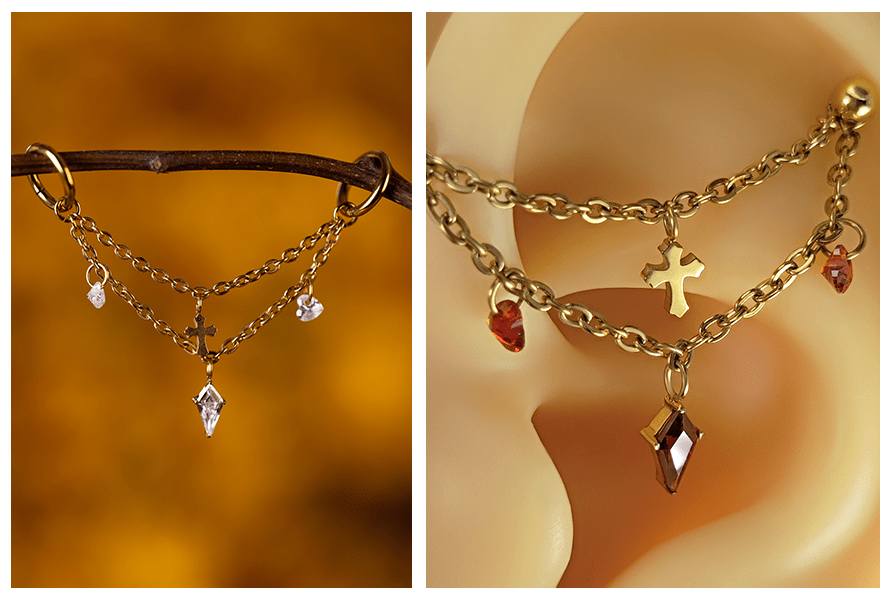 Złoty łańcuszek krzyż z dwoma sercami do piercingu ucha, zaprezentowany na gałązce oraz na modelu ucha w dwóch wersjach kolorystycznych kryształków