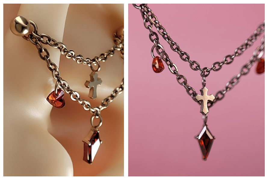 Srebrny łańcuszek krzyż z dwoma czerwonymi sercami do datek do kolczyków, pokazany na uchu oraz w zbliżeniu na różowym tle