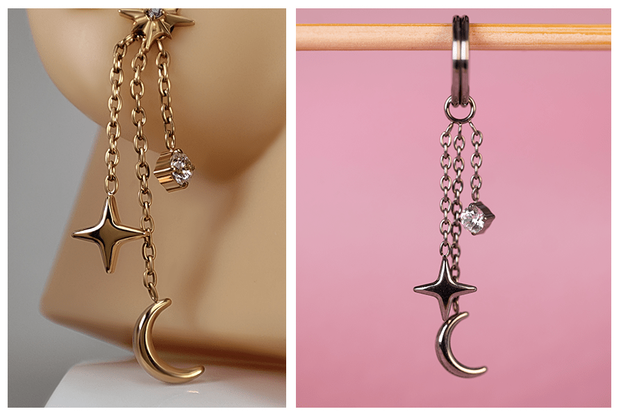 Łańcuszek księżyc z gwiazdką i kryształkiem do kolczyków – wersja w złotym i ciemnym odcieniu metalu, zaprezentowana na modelu ucha i zawieszona na patyczku na różowym tle
