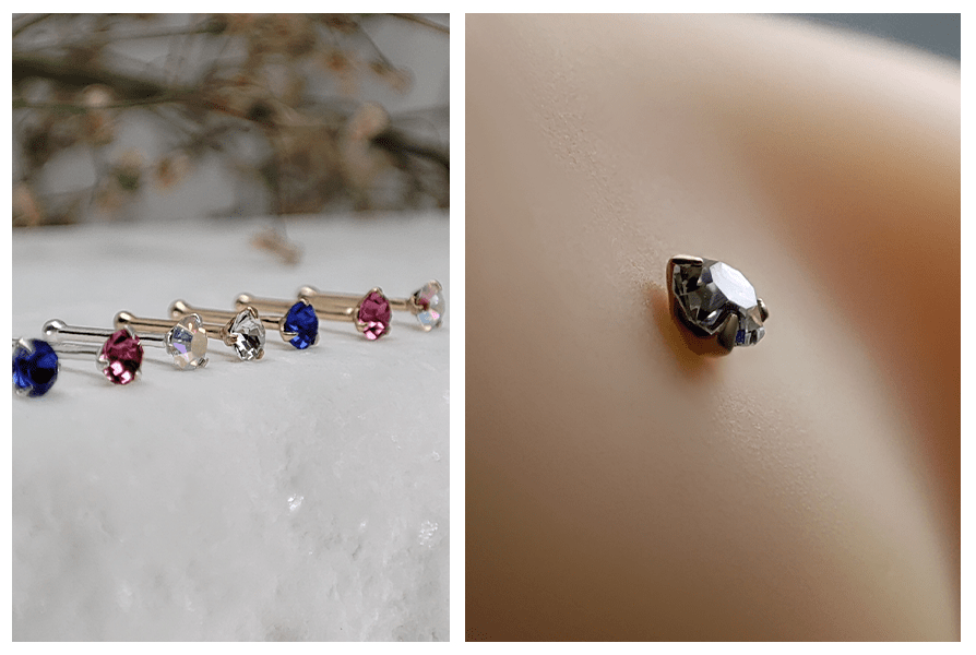 Proste kolczyki do nosa z kryształem w oprawie ułożone w linii na marmurowym tle oraz zbliżenie srebrnego kolczyka z przezroczystym kryształem w skrzydełku nosa