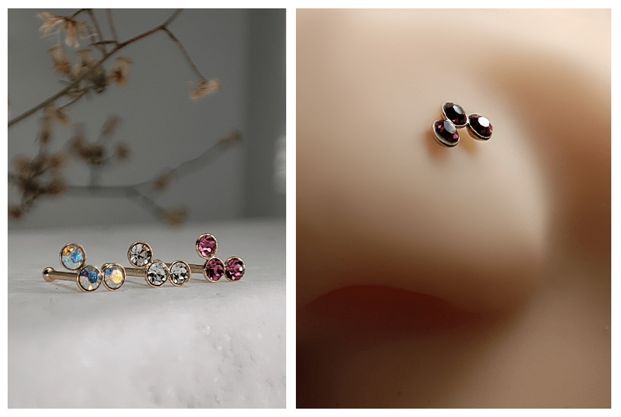 Proste kolczyki do nosa z trzema kryształkami w różnych kolorach ułożone na marmurowym tle oraz zbliżenie potrójnego kolczyka z ciemnymi kryształkami w nosie