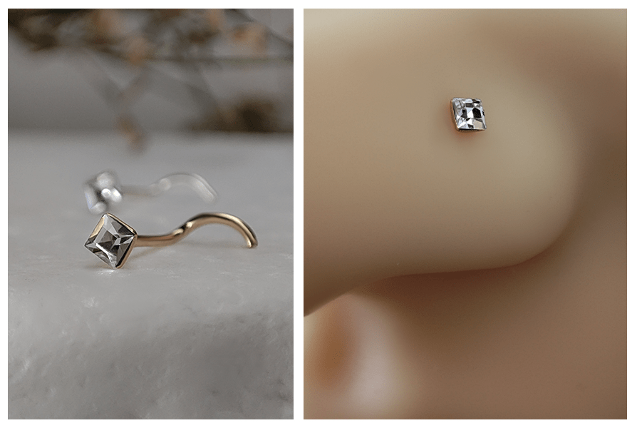 Zakręcony kolczyk do nosa z kwadratowym przezroczystym kryształem w złotej i srebrnej oprawie na marmurowym tle oraz zbliżenie małego kwadratowego kryształka w skrzydełku nosa