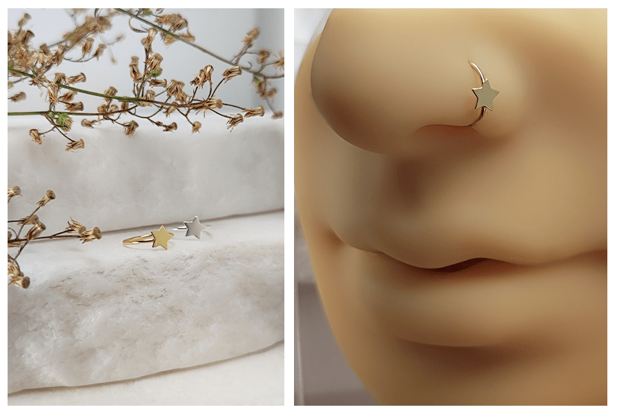 Kolczyk do nosa w formie rozginanego kółka z płaską gwiazdką w kolorze złotym i srebrnym, pokazany na jasnym kamiennym tle i na silikonowym modelu nosa