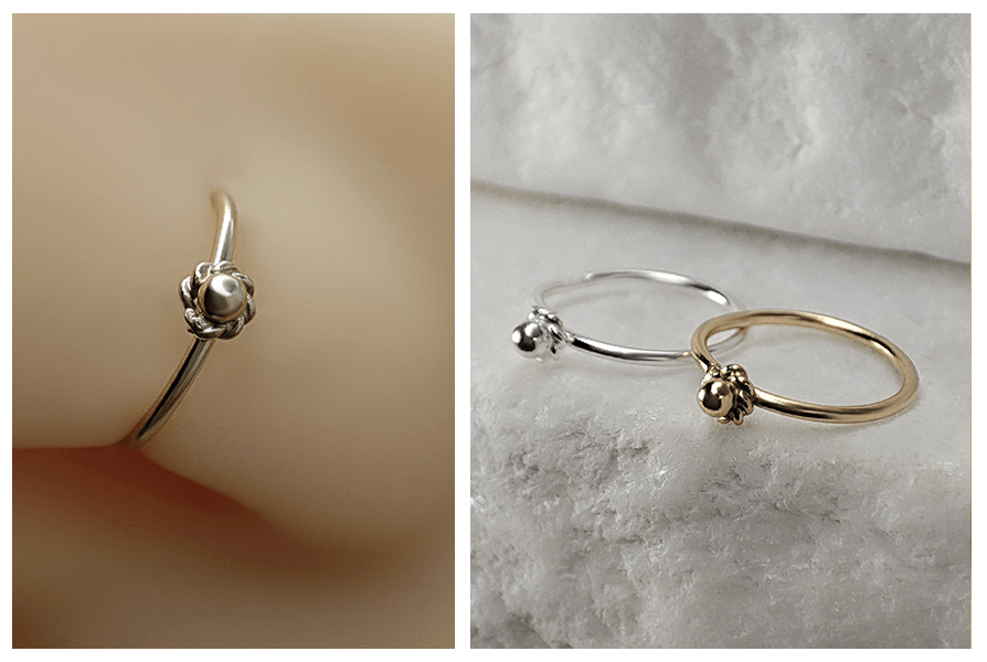 Delikatne kółko do nosa (srebro 925) z małym kwiatuszkiem w wersji złotej i srebrnej, ujęcie detalu na modelu oraz na jasnym kamiennym tle