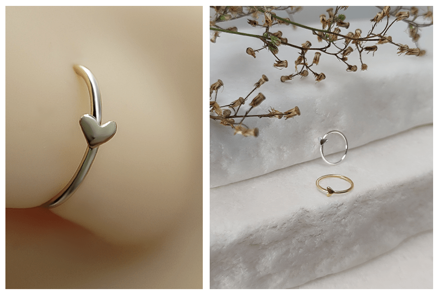 Kolczyk do nosa w formie kółka z małym serduszkiem w wersji srebrnej i złotej, zbliżenie na modelu oraz na jasnym kamiennym tle