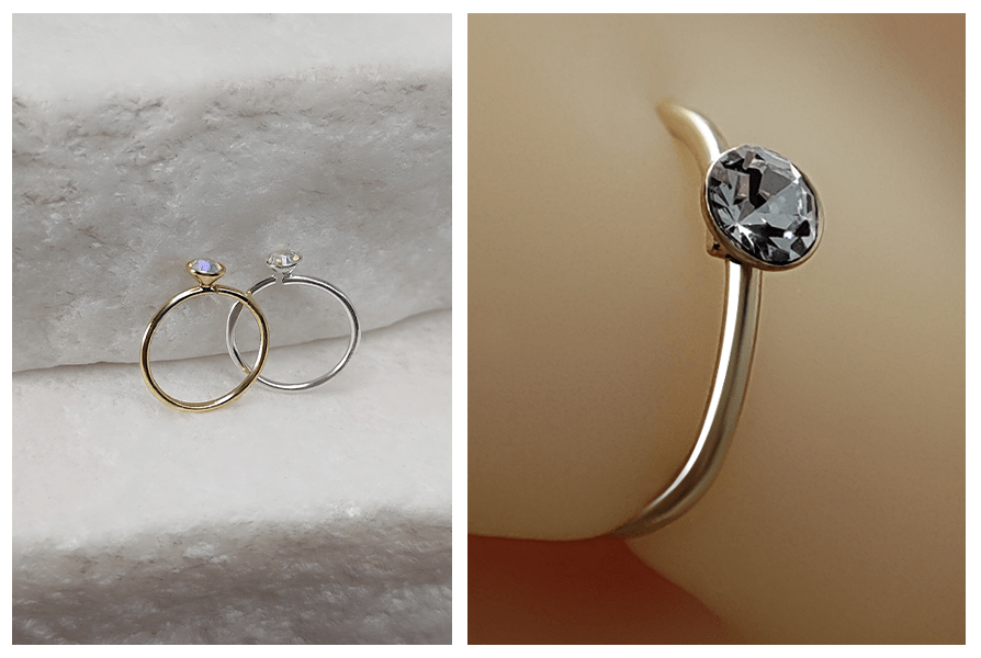 Rozginany model kolczyka do nosa pokazany z bliska oraz dwa kolczyki w złotym i srebrnym kolorze na kamieniu