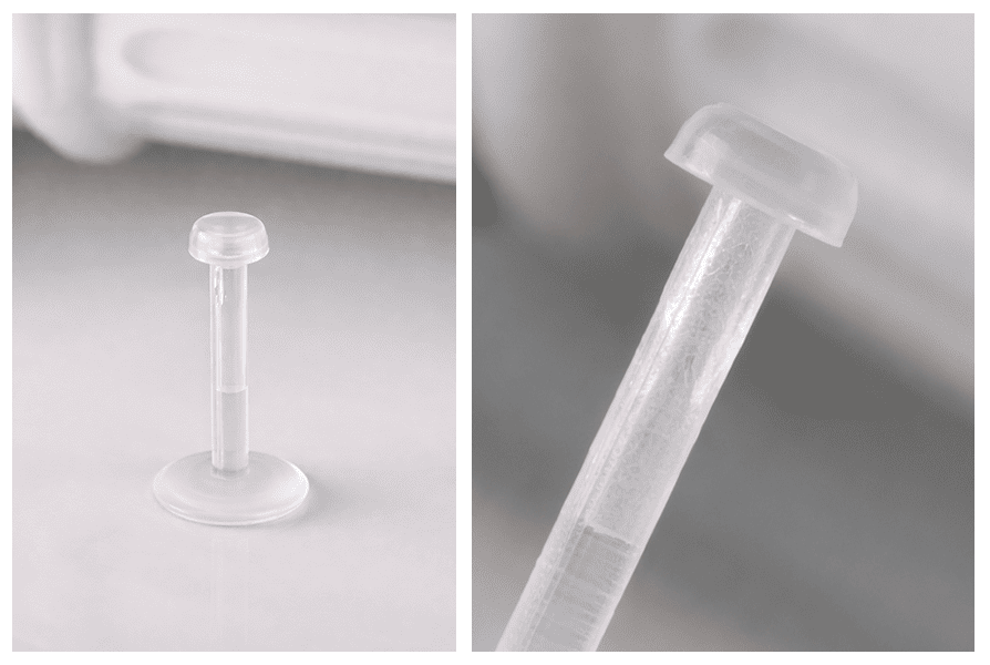 Kolczyk retainer typu labret z bioflexu z przezroczystą zatyczką, zaprezentowany w pozycji pionowej oraz w makro z widocznym detalem elastycznego pręcika