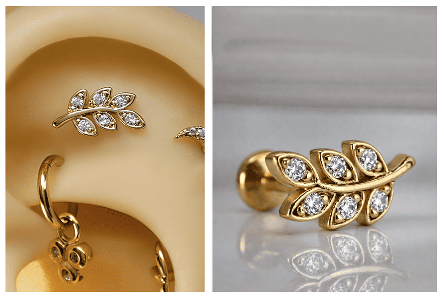 Złoty kolczykdo ucha ze stali chirurgicznej z motywem listka i przezroczystymi kryształkami, zaprezentowany w zbliżeniu na uchu oraz na jasnym tle