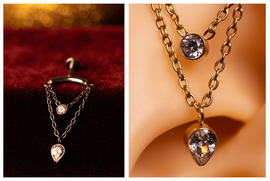 Wersja srebrna na czerwonym welurze: kolczyk z podwójnym łańcuszkiem i dwoma kryształkami (okrągły + łezka) – obok makro detalu łańcuszka i oprawy kamieni w silikonowym uchu