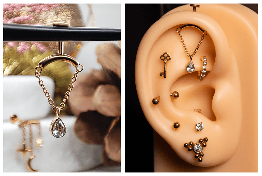 Złoty kolczyk z łańcuszkiem i zawieszką w kształcie klasycznej łezki z przezroczystym kamieniem – ujęcie na stojaku oraz założony w górnej części ucha jako labret do vertical helix