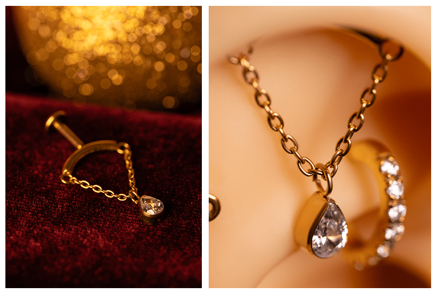 Kolczyk z łańcuszkiem i łezką z przezroczystym kamieniem sfotografowany na czerwonym welurze – obok zbliżenie w uchu pokazujące ogniwa łańcuszka i oprawę łezki