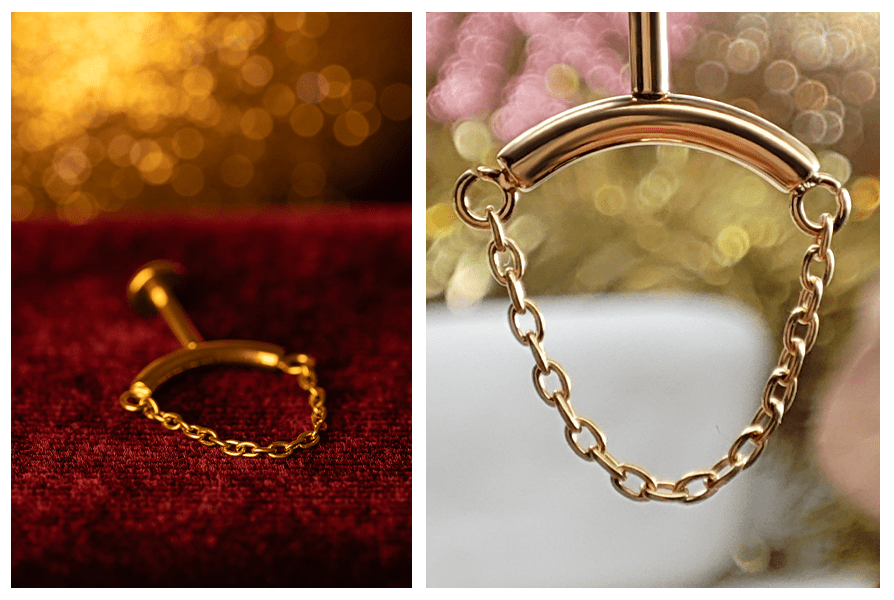 Kolczyk w kolorze złota z prostym łańcuszkiem sfotografowany na czerwonym tle z rozmytym światłem oraz makro łańcuszka na stojaku (labret do vertical helix)