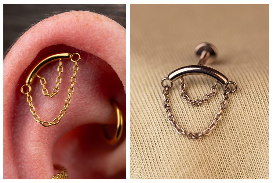 Zbliżenie na złoty labret z dwoma wiszącymi łańcuszkami w uchu, obok srebrnej wersji kolczyka prezentowanej osobno