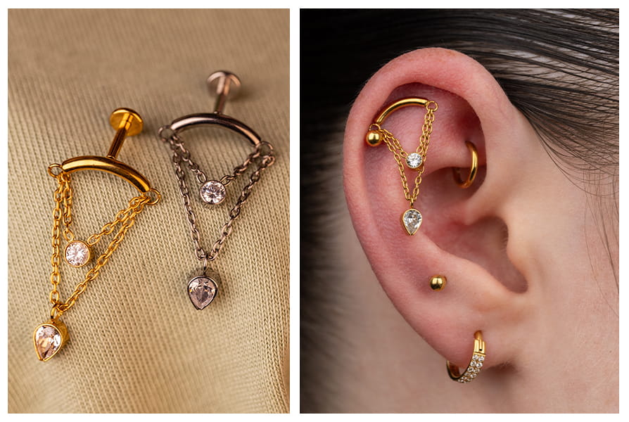 Labret z podwójnym łańcuszkiem i dwiema cyrkoniami w złotym oraz srebrnym kolorze, pokazany na jasnym tle i w stylizacji w uchu