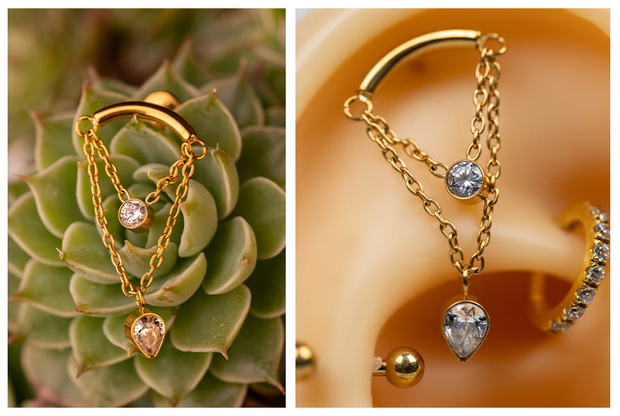 Złoty labret z podwójnym łańcuszkiem i dwiema cyrkoniami pokazany na tle sukulenta oraz na modelu ucha