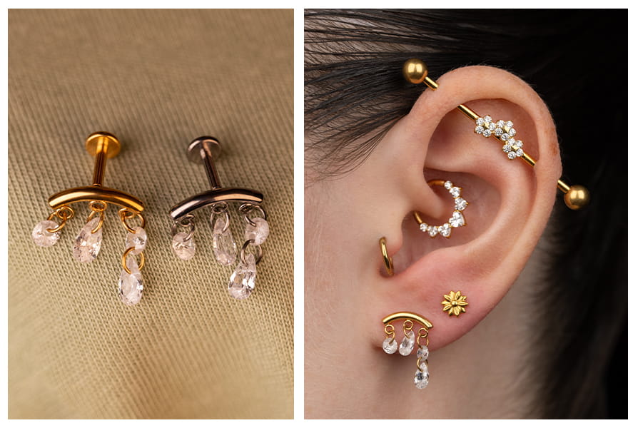 Labret z drobnymi wiszącymi cyrkoniami w złotym i ciemniejszym wykończeniu, pokazany na jasnym tle oraz w stylizacji na uchu