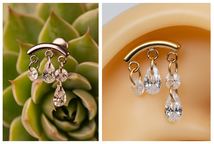 „Labret z drobnymi wiszącymi cyrkoniami pokazany na tle sukulenta oraz na modelu ucha, z subtelnym połyskiem kryształków