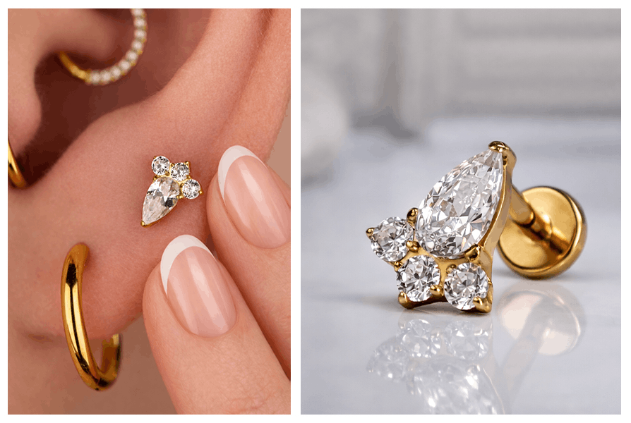 Złoty kolczyk labret z błyszczącą łezką i trzema cyrkoniami elegancko zaprezentowany na płatku ucha modelki