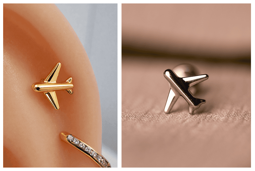 Zbliżenie złotego samolotu na silikonowym uchu (w kadrze też kolczyk z kryształkami); obok pojedynczy srebrny labret samolot na materiale