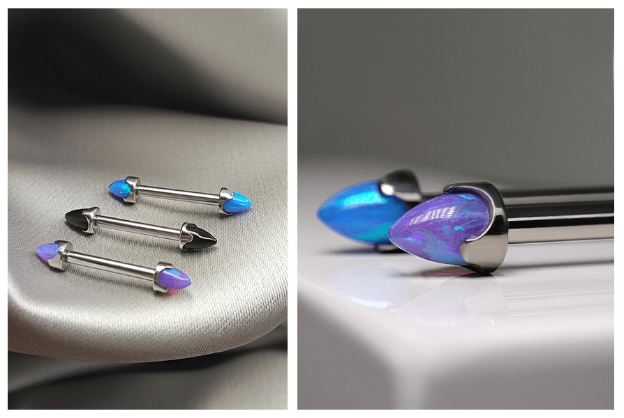 Kolczyk do sutka – sztanga z opalowymi stożkami „bullet” w odcieniach niebieskiego i fioletu, ujęcie całego zestawu na satynie