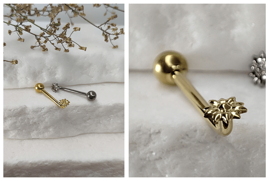 Złoty i srebrny kolczyk intymny Christina L-bar z kwiatkiem, ułożone na białym kamieniu i zbliżenie na złoty model
